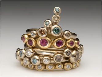 Stack of precious metal rings set with colourful semi-precious stones and diamonds